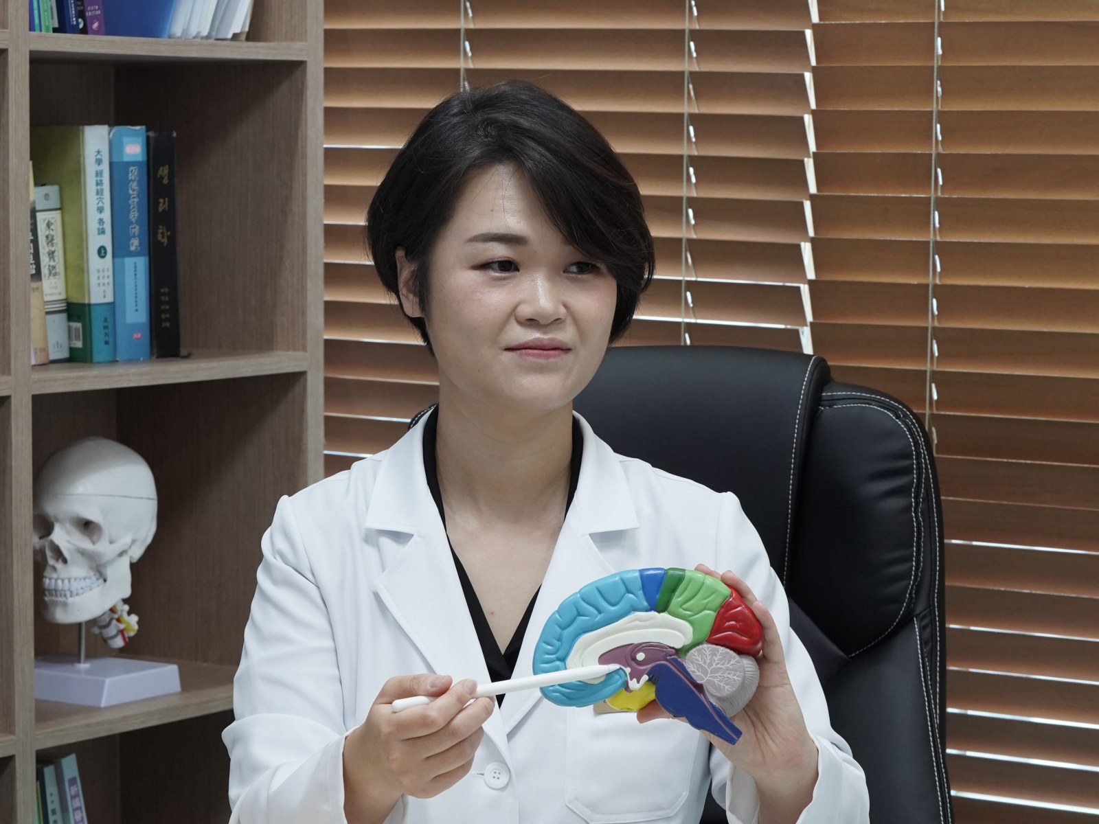 해아림한의원 부산서면점 초진 상담 — 맹아름 대표원장이 뇌 모형으로 설명하는 모습
